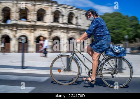 Scooter elettrico di fronte all'anfiteatro romano, Arena, stadio dei bullfighter Nimes, Dipartimento del Gard, Languedoc-Roussillon, Francia Foto Stock