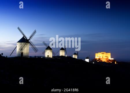 Vista dei mulini a vento e del castello di Consuegra a la Mancha, nella Spagna centrale di notte Foto Stock