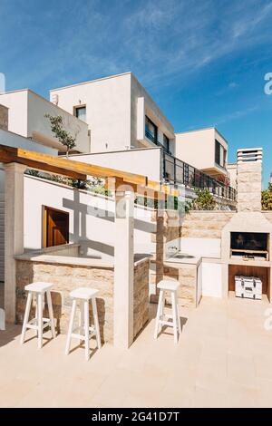 Area grigliata nella villa sul mare. Un ampio cortile con griglia in pietra e cucina aperta in pietra bianca. Foto Stock