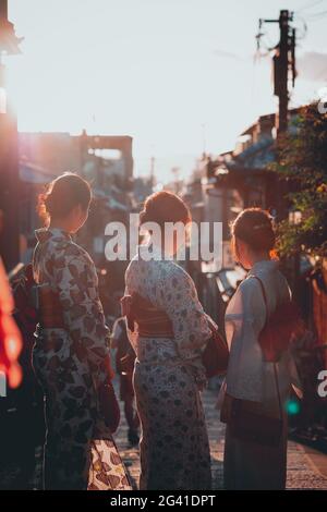 Donne al sole serale vestite in kimonos Kyoto, Giappone Foto Stock
