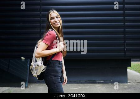 Ritratto di uno studente sorridente e che cammina per il campus Foto Stock