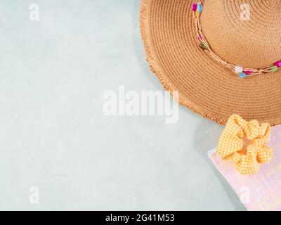 Estate luminoso sfondo in pietra grigio turchese con beauty bag e cappello di paglia Foto Stock