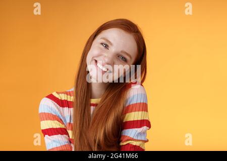 Tenero vivace allegro sorridente rosso ragazza europea 20s testa inclinabile spalla inclinata girando grinning carino fare belle labirinti Foto Stock