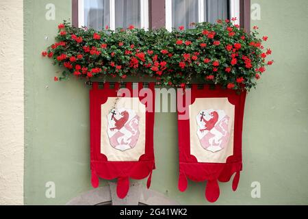 Rosso dei gerani e bandiere su una casa a Rothenburg Foto Stock