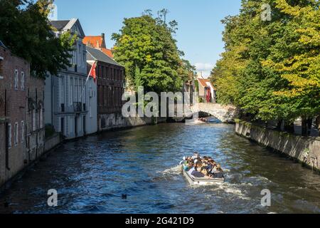 Tourist godendo di una gita in barca intorno a Bruges Fiandre Occidentali in Belgio Foto Stock