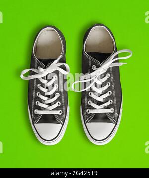 Sneakers nere isolate su sfondo verde Foto Stock
