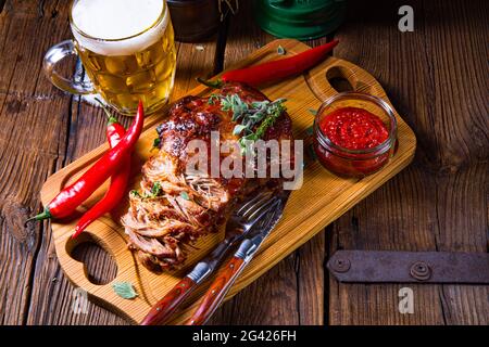 Carne di maiale tirata fuori dal forno con salsa di birra Foto Stock