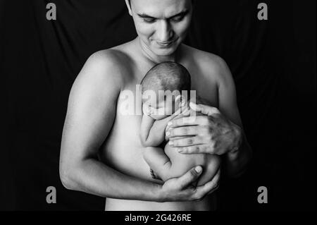 Padre che tiene la figlia appena nata ad un photoshoot neonato Foto Stock