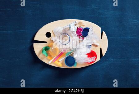 Pila di oggetti di plastica di scarto su un pesce di legno. Inquinamento marino o oceanico, conservazione ambientale e microplastica nel concetto alimentare. Foto Stock