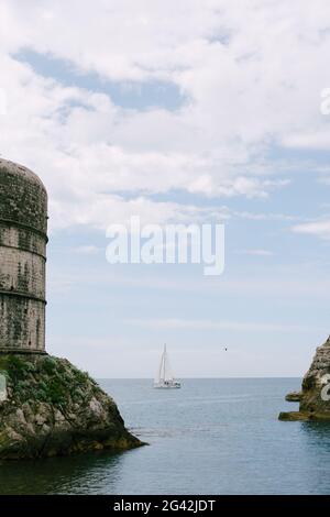 Barca a vela in mare, vela sullo sfondo Fort Bokar - sulle pareti della città vecchia di Dubrovnik, Croazia. Foto Stock