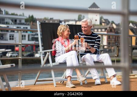 Coppia gustando cocktail sulla terrazza solarium della nave da crociera sul fiume durante una crociera sul Reno, vicino ad Andernach, Renania-Palatinato, Germania, Europa Foto Stock