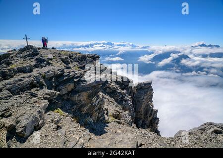 Due persone si trovano sulla cima della Grande Dent de Morcles con la croce sommitale, Monte Bianco sullo sfondo, Dent de Morcles, Alpi Bernesi, Vaud, Vaud, S Foto Stock
