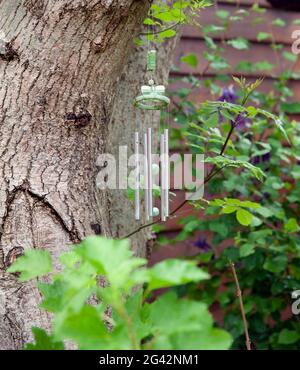 Interessanti cimini a vento in metallo appesi in giardino Foto Stock