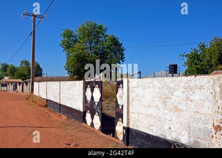 Gambia; Central River Region; Kuntaur; sulla strada principale; Muro con ingresso ad una proprietà privata Foto Stock