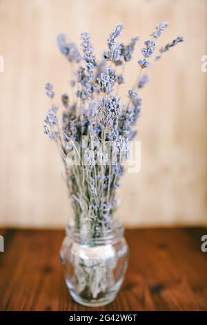 Un bouquet di lavanda secca in un vaso di vetro sul tavolo Foto Stock