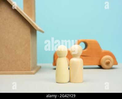 Casa di legno e auto con figure di famiglia in miniatura, ipoteca e concetto di prestito Foto Stock