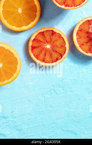 Arance fresche e succose, riprese dall'alto su sfondo blu Foto Stock