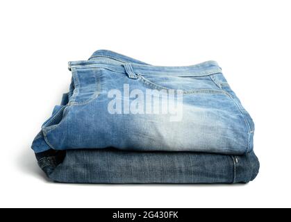 Jeans blu piegati da uomo su sfondo bianco Foto Stock