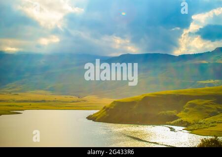 Drakensberg montagne e campana parco diga con luce solare durante il tramonto Foto Stock
