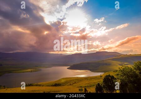 Drakensberg montagne e campana parco diga con luce solare durante il tramonto Foto Stock