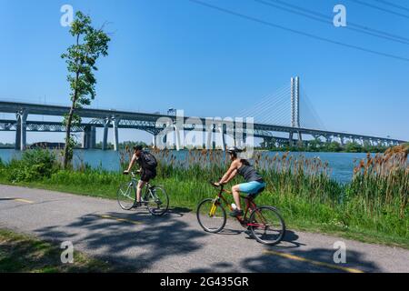 Brossard, CA - 31 luglio 2020: Pista ciclabile a Brossard, con il nuovo ponte Samuel de Champlain sullo sfondo Foto Stock