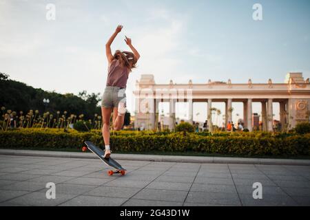 Giovane donna sportiva a bordo dello skateboard nel parco. Foto Stock