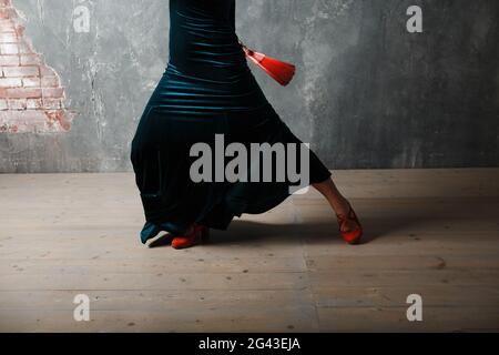 Giovane adulta spagnola donna che balla flamenco su sfondo grigio vintage Foto Stock