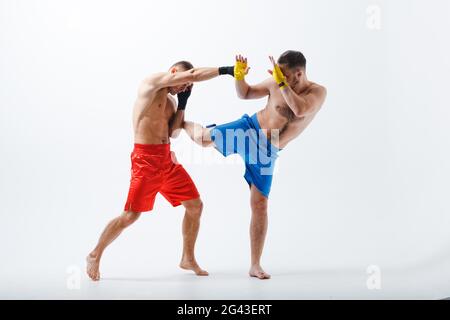 Due uomini boxer lotta muay thai boxing sfondo bianco Foto Stock