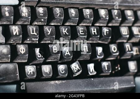 Primo piano di una macchina da scrivere obsoleta. Tastiera rotta con lettere russe. Foto Stock