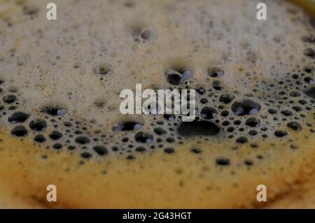 Macro shot di bevanda a base di caffè schiumoso, fondo di bevande astratte. Schiuma di caffè, bassa DOF. Foto Stock