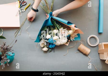 Fiorista donna fare bouquet in fiore boutique Foto Stock