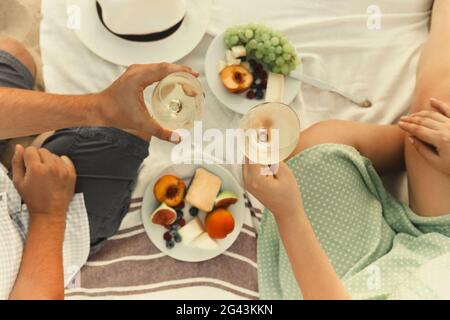 Raccolto coppia bere vino durante il picnic Foto Stock