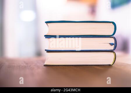 Concetto di conoscenza e scienza: Pila di libri che giacciono su scrivania di legno, casa. Foto Stock