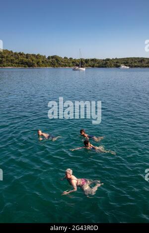 I passeggeri della nave da crociera nuotano in una baia incontaminata, vicino a Kukljica, Zara, Croazia, Europa Foto Stock