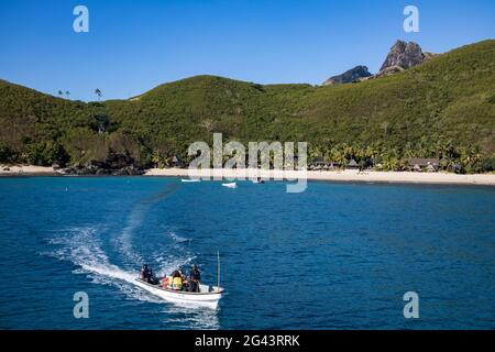 Trasferimento in barca locale dall'isola al catamarano Yasawa Flyer II (South Seas Cruises), all'Isola Waya, al Gruppo Yasawa, alle Isole Fiji, Sud Pacifico Foto Stock