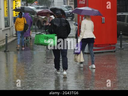 Bucarest, Romania - 18 giugno 2021: Un Uber mangia il corriere di consegna del cibo, piovuto e bagnato in acqua, consegna il cibo, in tempo piovoso, nel centro di Buche Foto Stock