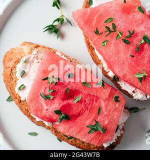 Toast con cocomero, formaggio morbido e timo Foto Stock