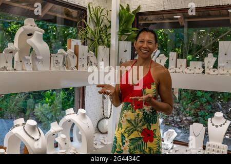 Donna allegra che presenta perle Tahitiane in vendita in un negozio di perle, Moorea, Isole Windward, Polinesia francese, Sud Pacifico Foto Stock