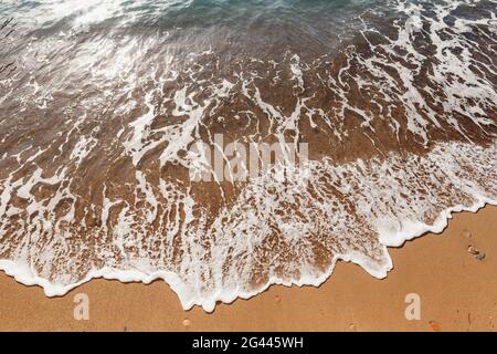 Surf in mare. L'onda scorre sulla spiaggia Foto Stock