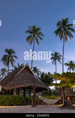 Amaca sulla spiaggia e bungalow del Sofitel Ia ora Beach Resort a daybreak, Moorea, Windward Islands, Polinesia francese, Sud Pacifico Foto Stock