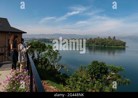 Le giovani donne si affacciano sul Lago Kivu dalla terrazza del Emeraude Kivu Resort con la città di Bukavu nella Repubblica Democratica del Congo nel dis Foto Stock