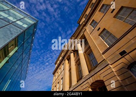 Giustapposizione di un moderno edificio in vetro e di un classico edificio a colonne. Bath, Regno Unito Foto Stock