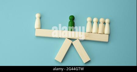 Le figure di legno degli uomini su un'oscillazione, fra loro un negoziatore. Il concetto di negoziato, la riconciliazione delle parti Foto Stock