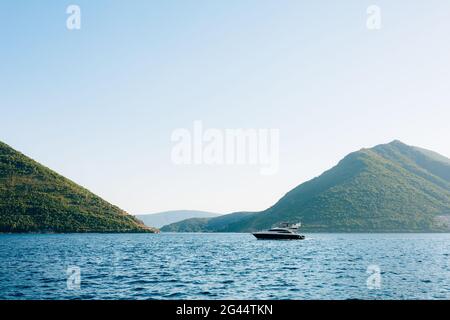 Il motoscafo galleggia sull'acqua. Giornata calda di sole nella città di Perast. Foto Stock