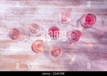 Tipi di vino rosato, girato dall'alto, tonificato in rosa, molti bicchieri di vino Foto Stock