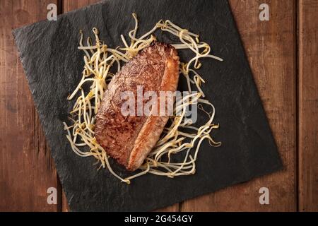 Carne di Kobe, bistecca di manzo di wagyu, cucinata, con germogli di soia, sparato dall'alto Foto Stock