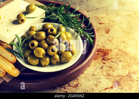Gustose olive verdi greche fresche con feta al formaggio o formaggio di capra. Primo piano. Cibo mediterraneo. Toning. Foto Stock