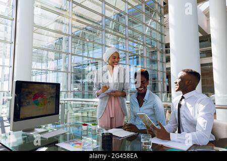 Maschi e femmine dirigenti interagire gli uni con gli altri al banco Foto Stock