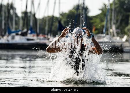 Northeim, Germania. 19 giugno 2021. Il nuotatore e triatleta Chris Lemke di Einbeck si raffredda di mattina presto dopo l'allenamento alle temperature estive nel distretto del lago di Northeim, di fronte alle barche a vela su un molo con acqua. Credit: Swen Pförtner/dpa/Alamy Live News Foto Stock