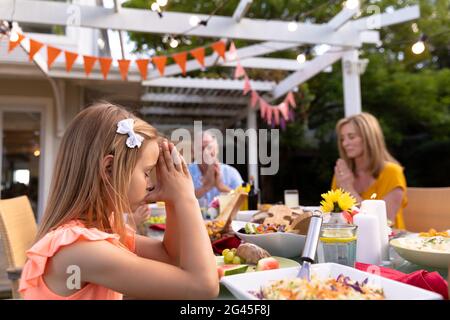 Famiglia caucasica che dice grazia insieme prima di mangiare Foto Stock